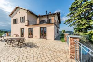 einen Außenblick auf ein Haus mit einer Terrasse in der Unterkunft Villa Bricco Paglieri, entire Villa in Alba
