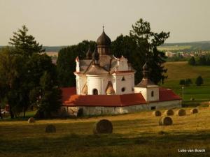 duży budynek na polu z belkami siana w obiekcie Ubytování Svatá Trojice w mieście Trhové Sviny