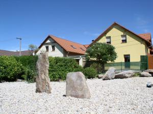 a group of rocks sitting on the beach in front of a house at Ubytování Svatá Trojice in Trhové Sviny