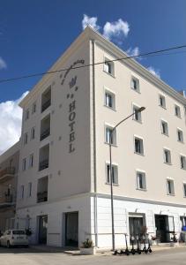 Ein weißes Gebäude mit einem Schild drauf. in der Unterkunft D'Angelo Palace Hotel in Mazara del Vallo