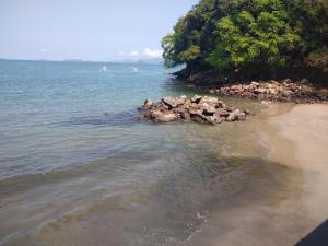 a group of rocks in the water on a beach at Aconchego da Floresta in Angra dos Reis +4 photos