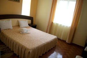 1 dormitorio con 1 cama con sábanas blancas y ventana en Maria, en Eforie Sud