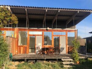 a house with glass doors and a table on a deck at Seevilla Matilda direkt am Ufer in Jois