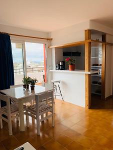 a kitchen and a dining room with a table and chairs at Apartamentos Ebusus in Santa Eularia des Riu +12 photos