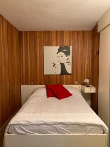 een slaapkamer met een wit bed en een rood kussen bij Casa di Valentina in Breuil-Cervinia