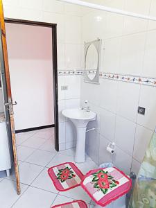 a white bathroom with a sink and a toilet at Ubatuba Beach House in Ubatuba