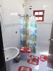 a bathroom with a toilet and a shower curtain at Ubatuba Beach House in Ubatuba