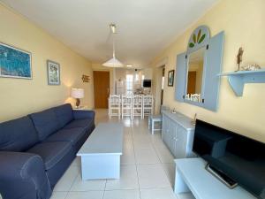 a living room with a blue couch and a tv at Apartments Bambu in San Agustin