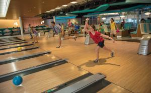 a young girl playing bowling in a bowling alley at Universal's Cabana Bay Beach Resort in Orlando