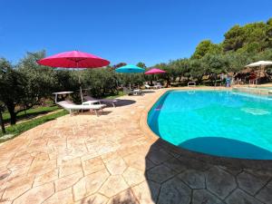 a swimming pool with umbrellas and chairs and a pool at Recidence Villa Olivia in Itri