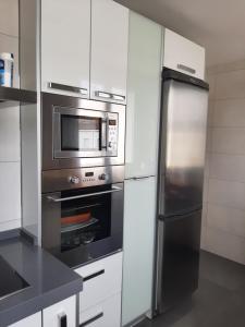 a kitchen with a stainless steel refrigerator and a microwave at Atico en el centro de Vitoria Parking gratis in Vitoria-Gasteiz