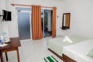 ネゴンボにあるAraliya Lagoon Park Resortのベッド2台とテレビが備わるホテルルームです。