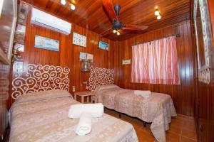 - une chambre avec 2 lits et un ventilateur de plafond dans l'établissement Disfruta del paraíso en primera línea de playa con Kayak y Paddle Surf, à El Rompido