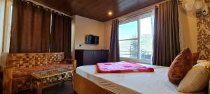 a bedroom with a bed and a window and a chair at Rashal Homes in Shogi