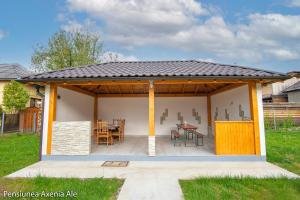a pavilion with a table and chairs in a backyard at Pensiunea Axenia Ale in Vişeu de Sus
