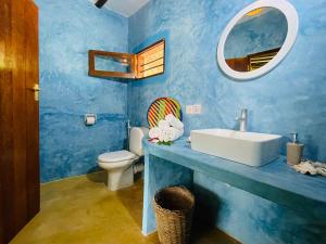 a blue bathroom with a sink and a toilet at Oleza Boutique Hotel Zanzibar in Michamvi +69 photos