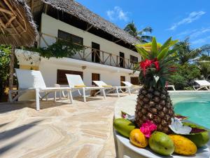 un ananas seduto su un tavolo accanto alla piscina di Oleza Boutique Hotel Zanzibar a Michamvi Kae