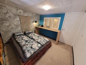 Dormitorio pequeño con cama y espejo en Appartement, atelier d'artiste, en Chelles