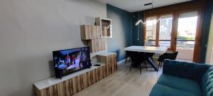 uma sala de estar com uma televisão e uma mesa de jantar em Los Sitios em Astorga