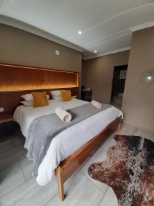 a bedroom with a large bed with a wooden headboard at Casa Cara Guest House in Parys