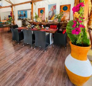 a dining room with a table and a vase with flowers at Oleza Boutique Hotel Zanzibar in Michamvi
