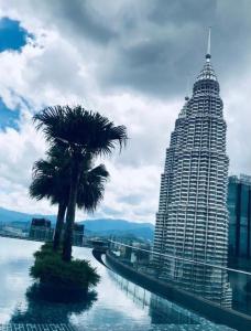 a palm tree sitting next to a large building at Cozy 2BR Suite 2 Min to KLCC and Saloma bridge in Kuala Lumpur