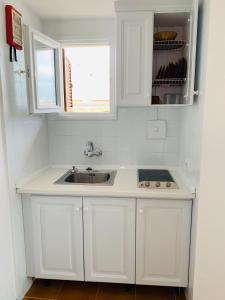a white kitchen with a sink and a window at Apartamentos Ebusus in Santa Eularia des Riu