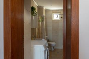 a bathroom with a white toilet and a sink and a toilet istg at Apartment VEDA - Апартамент ВЕДА in Veliko Tŭrnovo