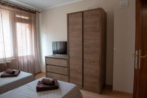 a bedroom with two beds and a dresser with a television at Apartment VEDA - Апартамент ВЕДА in Veliko Tŭrnovo +15 photos