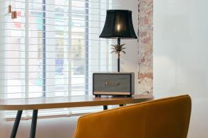 a desk with a laptop and a lamp on it at RITCH Aparthotel Alkmaar in Alkmaar