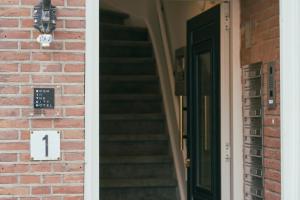 a brick building with a black door and stairs at RITCH Aparthotel Alkmaar in Alkmaar
