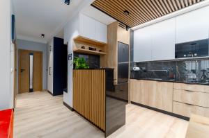 a kitchen with white cabinets and a large window at Apartament Eveline in Rzeszów