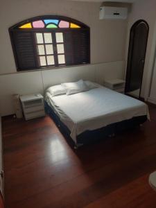 a bed in a room with a window and a bed sidx sidx sidx at Casa das Dunas in Tamoios