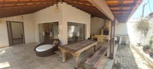 a porch with a wooden bench and a tub at Casa das Dunas in Tamoios