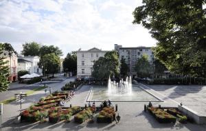 a fountain in the middle of a courtyard with buildings at Apartamenty Weneckie in Zielona Góra