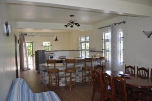 cocina y comedor con mesa y sillas en Moringi (Veer Residences) en Trou dʼ Eau Douce