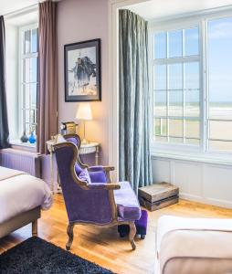 une chambre d'hôtel avec une chaise violette et des fenêtres dans l'établissement La Goélette, Chambres d'Hôtes, à Wimereux