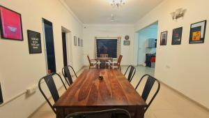 a dining room with a wooden table and chairs at Lifespace- Spacious Hostel in a Luxurious Villa in Pune