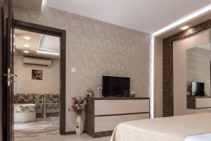 een slaapkamer met een bed en een tv in een kamer bij Apartment Central-LUX in Veliko Tŭrnovo