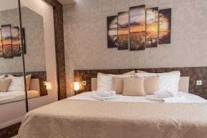 - une chambre avec un lit orné de 4 peintures murales dans l'établissement Apartment Central-LUX, à Veliko Tarnovo