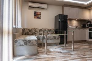 een keuken met een bank, een tafel en een koelkast bij Apartment Central-LUX in Veliko Tŭrnovo