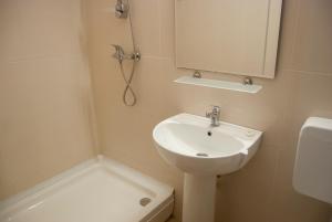 ein Badezimmer mit einem Waschbecken, einem Spiegel und einem WC in der Unterkunft Hotel Prahova in Saturn
