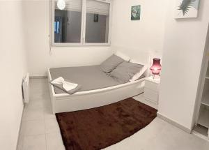 a small white room with a bed and a window at LE VELODROME Chic appartement in Marseille
