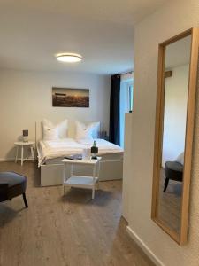 1 dormitorio con cama y mesa con espejo en LandZAUBER Apartment Ferienwohnung en Beiersdorf