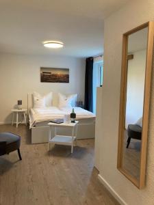 a bedroom with a bed and a table with a mirror at LandZAUBER Apartment Ferienwohnung in Beiersdorf