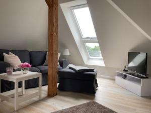a living room with a blue couch and a tv at LandZAUBER Apartment Ferienwohnung in Beiersdorf
