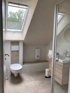 a bathroom with a toilet and a sink and a window at LandZAUBER Apartment Ferienwohnung in Beiersdorf +18 photos