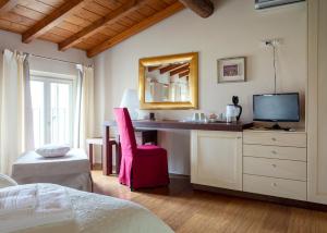 um quarto com uma secretária, uma televisão e uma cama em Corte dei Soavi em Soave