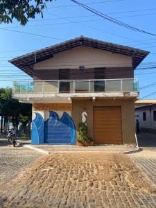 a house with a garage on the side of it at Pousada Vila do Mar in Taíba