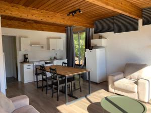 kuchnia i salon ze stołem i krzesłami w obiekcie Barcelonnette location avec jardin w mieście Barcelonnette